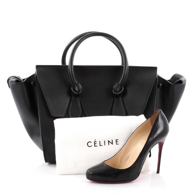 This authentic Celine Tie Knot Tote Smooth Leather Large is an absolute must-have for serious fashionistas. Crafted from black smooth leather, this boxy, chic tote features dual-rolled leather handles with signature knot accents, subtle stamped gold