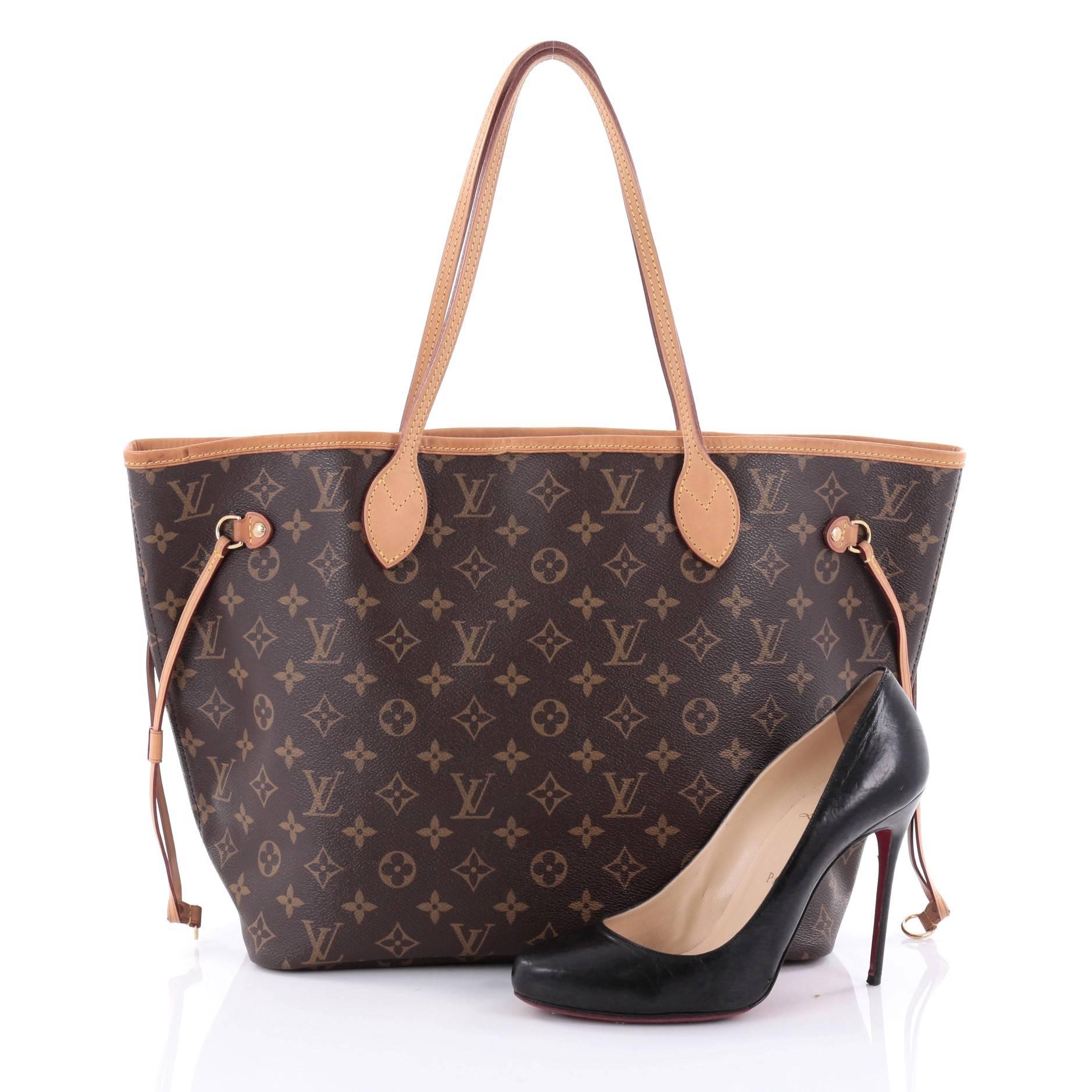 This authentic Louis Vuitton Neverfull Tote Monogram Canvas MM is a popular and practical oversized tote beloved by many. Constructed with Louis Vuitton's signature brown monogram coated canvas, this tote features dual slim vachetta leather handles,