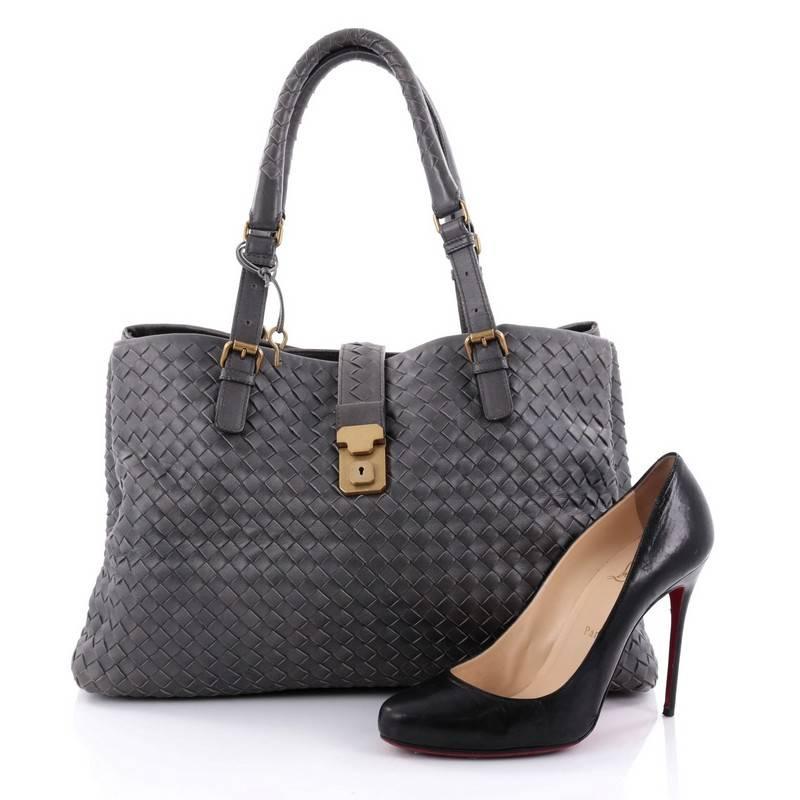 This authentic Bottega Veneta Roma Handbag Intrecciato Nappa Medium is a finely crafted tote that exudes an understated elegance. Crafted from grey nappa leather woven in Bottega Veneta's signature intrecciato method, it features dual woven leather