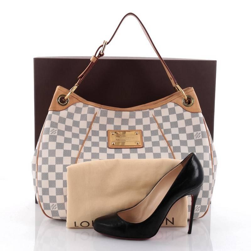 This authentic Louis Vuitton Galliera Handbag Damier PM is a practical and iconic bag that's a favourite among LV collector's everywhere. Crafted from Louis Vuitton's damier azur coated canvas, this bag features an adjustable belted leather shoulder