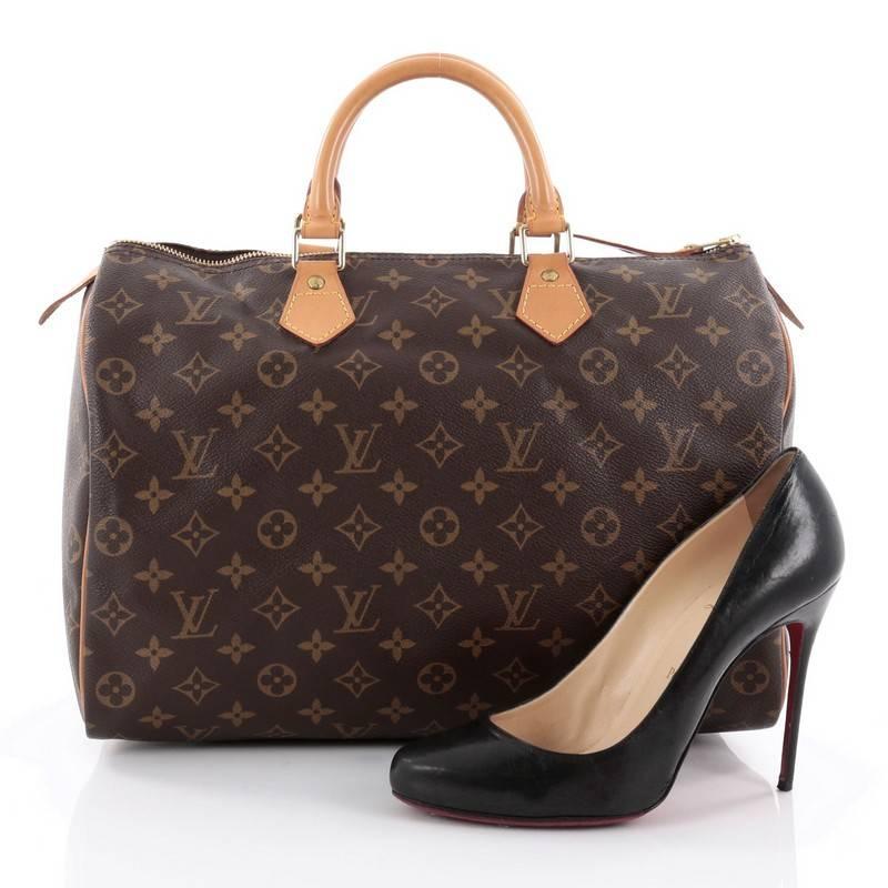 This authentic Louis Vuitton Speedy Handbag Monogram Canvas 35 is spacious and light, making it ideal to use everyday. Constructed in Louis Vuitton's classic brown monogram coated canvas, this iconic Speedy features dual-rolled leather handle,