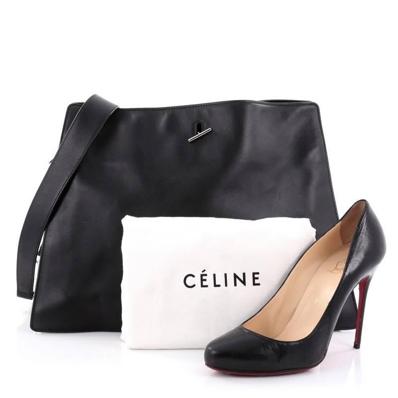 This authentic Celine New Shoulder Bag Smooth Calfskin Large presented in the brand's Fall/Winter 2012 Collection is an elegant, minimalist bag made for any casual or sophisticated outfit. Crafted of black smooth calfskin, accented with silver-tone