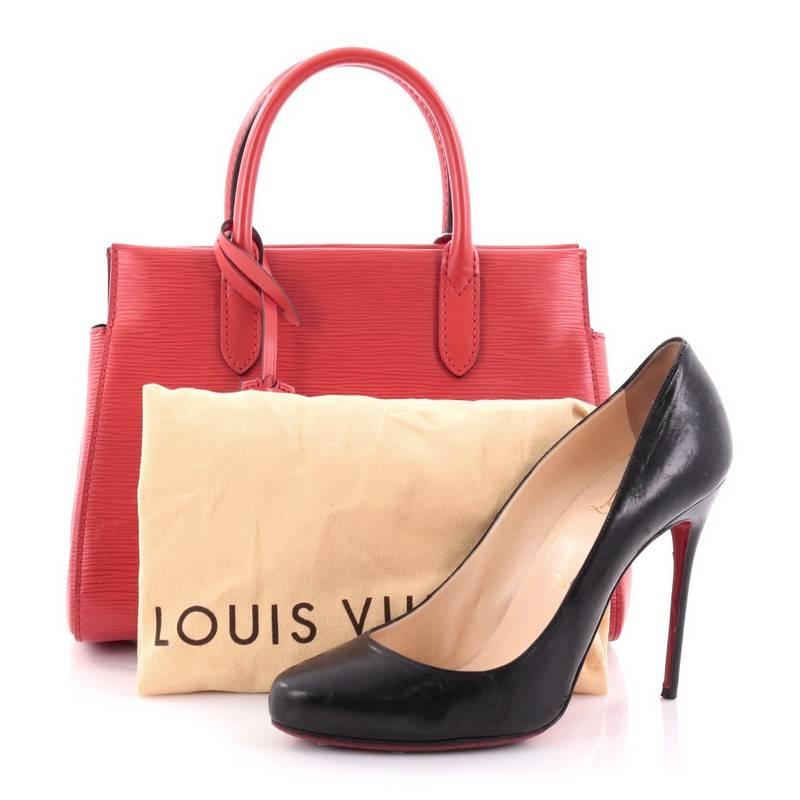 This authentic Louis Vuitton Marly Handbag Epi Leather BB exudes casual sophistication perfect for the modern woman. Crafted in sturdy red epi leather, this structured working tote features an angular silhouette, dual-rolled leather handles, subtle