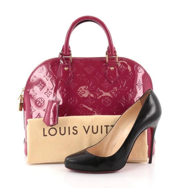 This authentic Louis Vuitton Alma Handbag Monogram Vernis PM is a fresh and elegant spin on a classic style that is perfect for all seasons. Crafted from Louis Vuitton's indian rose monogram vernis, this dome-shaped satchel features dual-rolled