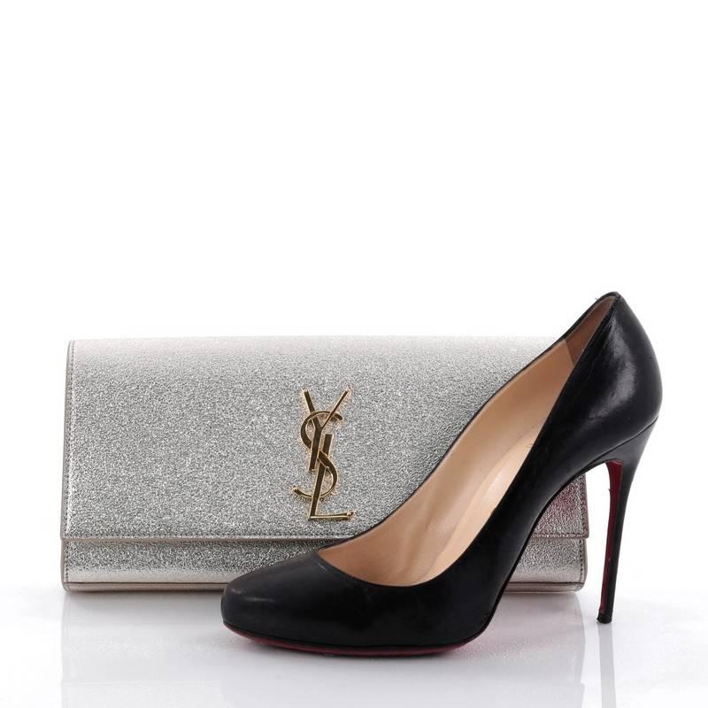 This authentic Saint Laurent Classic Monogram Clutch Leather Medium adds a touch of glamour to your nighttime look. Crafted in metallic silver leather, this elegant clutch features an iconic gold YSL monogram logo on its flap and gold-tone hardware