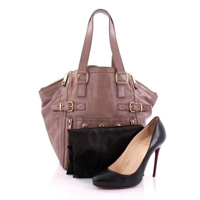 This authentic Saint Laurent Downtown Tote Leather Small is an edgy daily bag for the modern woman. Constructed from light brown leather, this smaller-sized tote features dual tall straps, buckle accents, exterior front zipped pocket and gold-tone