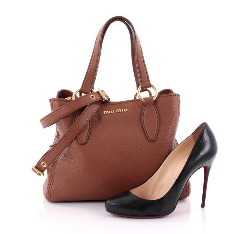 This authentic Miu Miu Phenix Convertible Tote Leather Medium is a classic everyday bag for any fashionista. Crafted with brown leather, this bag features dual-flat leather shoulder straps, raised Miu Miu logo at front, protective base studs and