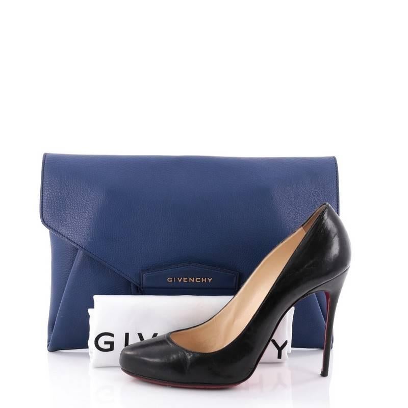 This authentic Givenchy Antigona Envelope Clutch Leather Medium is ideal for day to evening outfits. Crafted in blue leather, this clutch features an envelope flap-top with raised Givenchy logo and magnetic flap that tucks into slot . Its flap opens