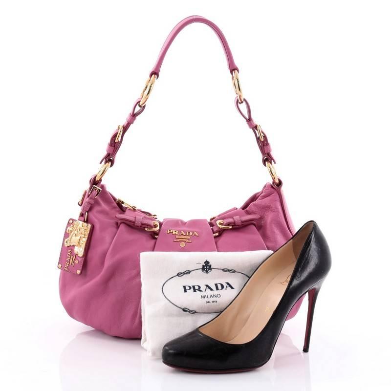 This authentic Prada Buckle Pleated Shoulder Bag Soft Calfskin Medium is ideal for everyday use. Crafted in fuchsia pink calfskin leather, this pleated bag features a single looped leather strap, front buckle detailing, raised Prada logo and