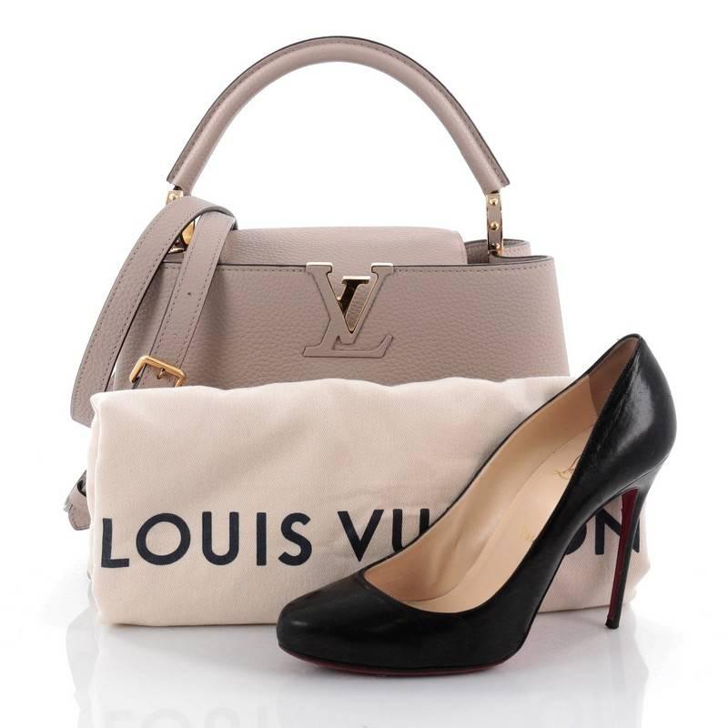 This authentic Louis Vuitton Capucines Handbag Leather PM is a sophisticated and ladylike luxurious bag inspired by its Parisian heritage. Crafted from light taupe taurillion leather, this chic, stand-out bag features a single loop leather handle