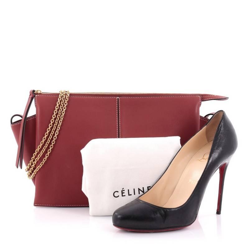 This authentic Celine Tri-Fold Clutch on Chain Smooth Leather is the perfect accessory to carry all day. Crafted from red smooth leather, this chic clutch features detachable chain strap and gold-tone hardware accents. Its zip closure opens to a red