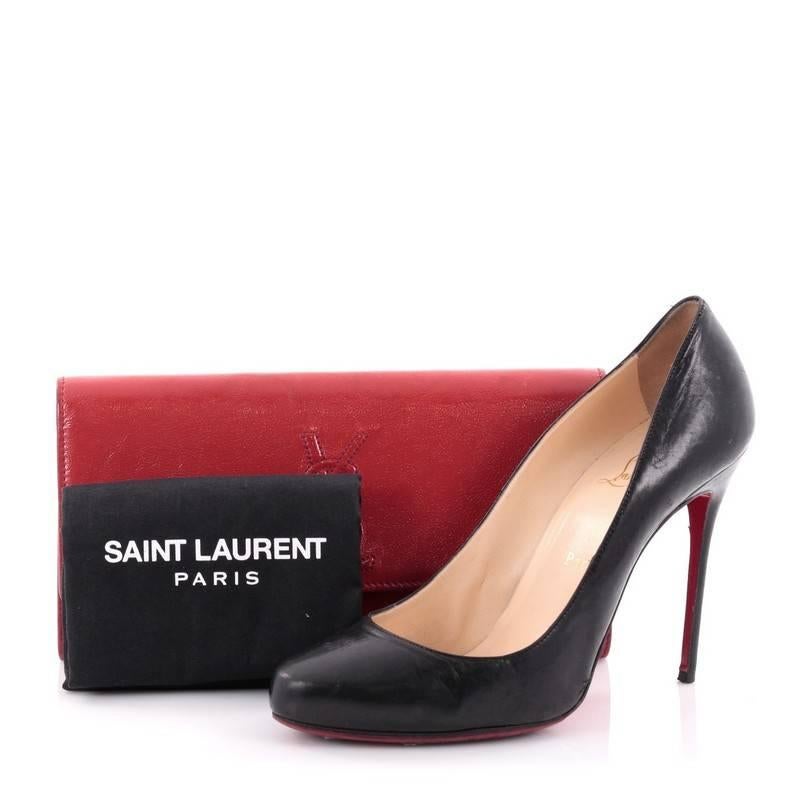 This authentic Saint Laurent Belle de Jour Clutch Leather Small is a chic and glamorous accessory to complement nightly looks. Crafted from luxurious red textured patent leather, this clutch features an embossed YSL monogram logo and gold-tone