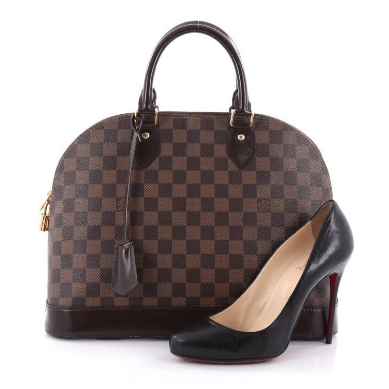 This authentic Louis Vuitton Alma Handbag Damier MM is a versatile structured bag that complements both dressy and casual look perfect for the modern woman. Designed with damier ebene coated canvas with chocolate brown leather trims, this structured