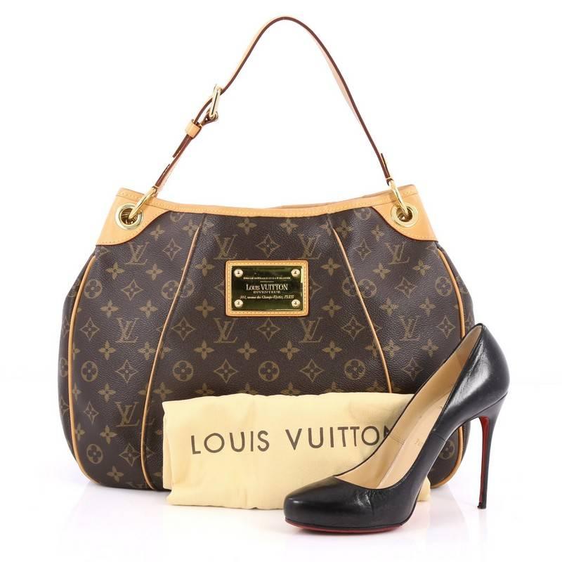 This authentic Louis Vuitton Galliera Handbag Monogram Canvas PM is as practical as it is iconic. Constructed from brown monogram coated canvas, this bag features adjustable shoulder strap, cowhide leather trims, metal logo plate accent, protective