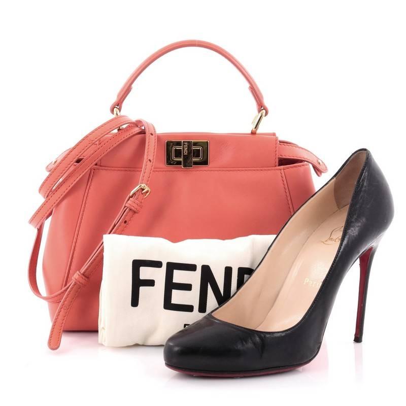 This authentic Fendi Peekaboo Handbag Leather Mini is one of Fendi's most sought-after design. Crafted from salmon leather, this mini-size satchel is accented with a top frame silhouette, flat leather handle, dual compartments with turn-lock and