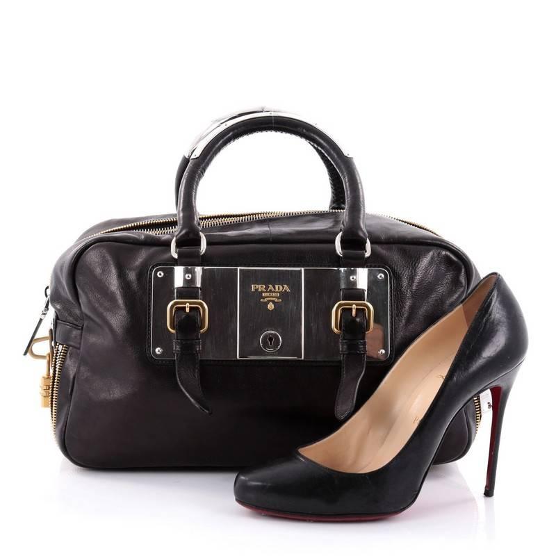 This authentic Prada Lock Plate Zippers Satchel Glace Calf Large is the perfect bag to pair with your day or evening outfits. Crafted in black glace calf leather, this chic bag features dual-rolled leather handles with silver links and buckles,