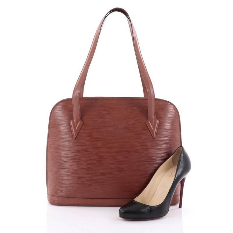 This authentic Louis Vuitton Lussac Handbag Epi Leather is a chic and sophisticated bag perfect for your everyday use. Constructed with Louis Vuitton's brown epi leather, this bag features dual flat leather straps, subtle LV logo, a dome-like