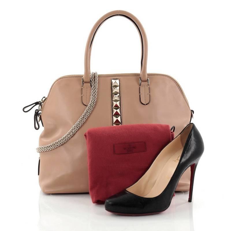 This authentic Valentino Va Va Voom Bowling Bag Leather Medium mixes bold and chic style. Crafted in nude leather, this edgy, sleek bag features dual-rolled leather handles, gold chain straps, signature pyramid rockstud detailing, protective base