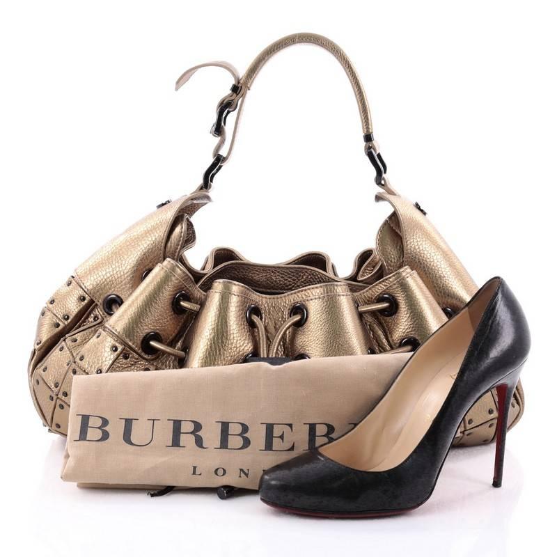 This authentic Burberry Warrior Hobo Patchwork Leather Medium is inspired by today's modern-day warrior. Crafted in gold leather with "armored" plates design, this unique hobo features an adjustable wide shoulder strap, top drawstring