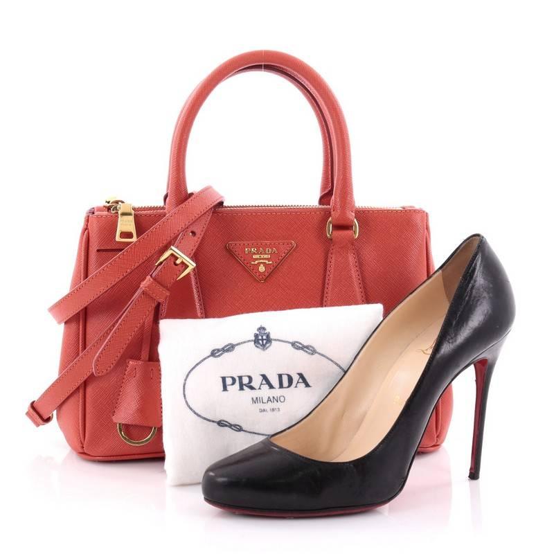 This authentic Prada Double Zip Lux Tote Saffiano Leather Mini is the perfect bag to complete any outfit. Crafted from red orange saffiano leather, this boxy petite bag features side snap buttons, raised Prada logo plate, dual-rolled leather
