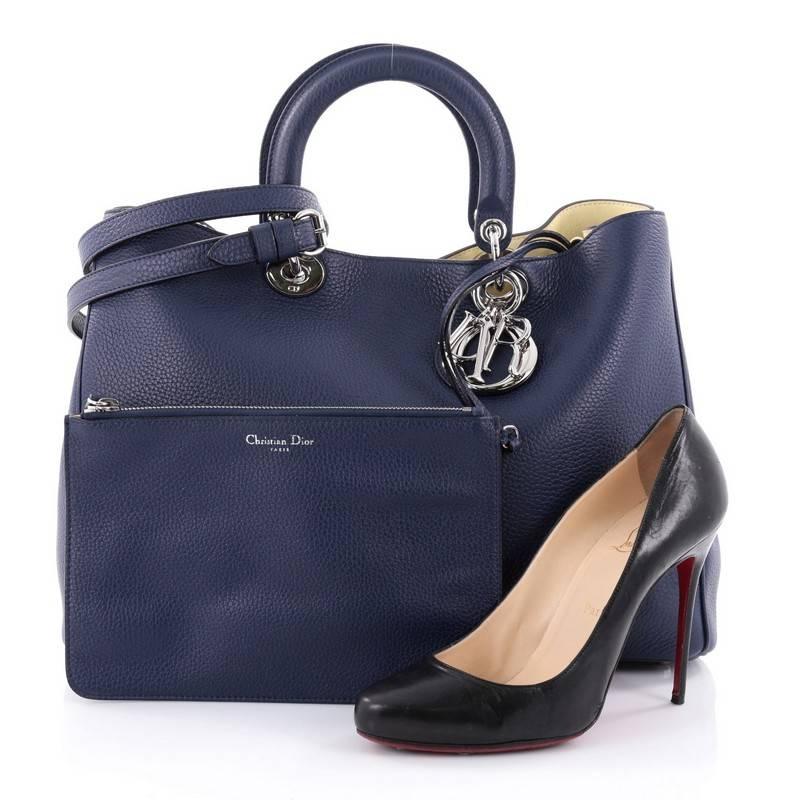 This authentic Christian Dior Diorissimo Tote Pebbled Leather Large is an elegant, classic statement piece that every fashionista needs in her wardrobe. Crafted from dark blue pebbled leather, this chic tote features smooth short dual handles with
