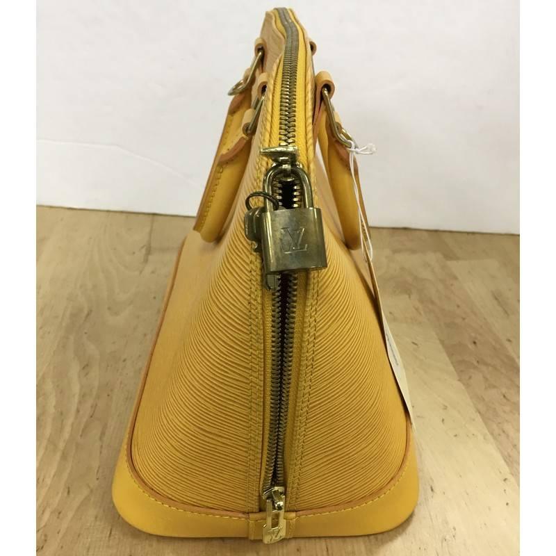 This authentic Louis Vuitton Vintage Alma Handbag Epi Leather PM is a chic and sophisticated bag perfect for your everyday use. Constructed from Louis Vuitton's signature sturdy yellow epi leather, this bag features dual-rolled leather handles,