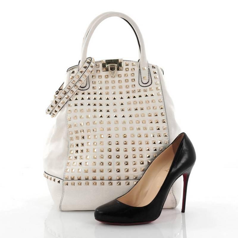 This authentic Valentino Rockstud New Dome Convertible Bucket Bag Full Studded Leather combines a refined design with stylish functionality perfect for any on-the-go fashionista. Crafted from white studded leather, this structured bucket-style tote
