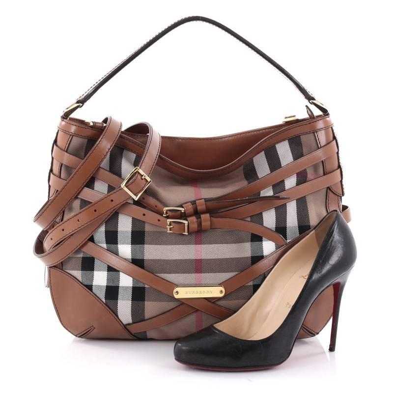This authentic Burberry Bridle Dutton Hobo House Check and Leather is a marvellous hobo, ideal for everyday use. Crafted from Burberry house check canvas, this stylish bag features looping top handle, flat leather detachable long shoulder strap,