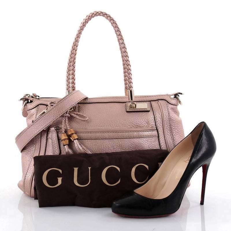 This authentic Gucci Bella Convertible Top Handle Bag Leather Small is perfect for everyday looks. Crafted in metallic rose leather, this tote features braided leather shoulder straps, leather tassels with bamboo details, exterior zip pocket,