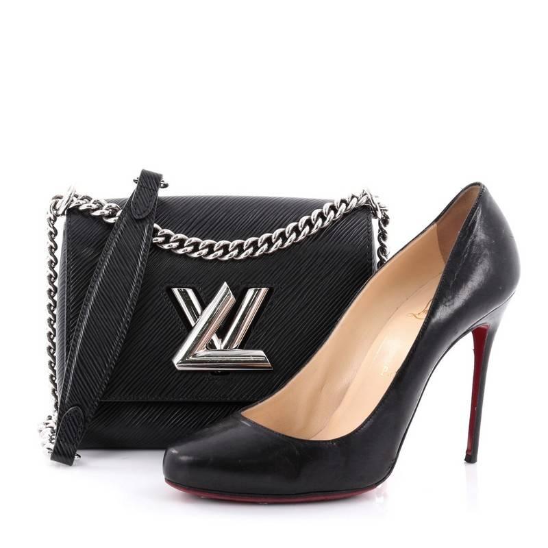 This authentic Louis Vuitton Twist Handbag Epi Leather PM is a coveted piece exuding a luxurious design with contemporary flair. Crafted in black epi leather, this chic bag features a waved base silhouette, silver chain link strap with leather pad,