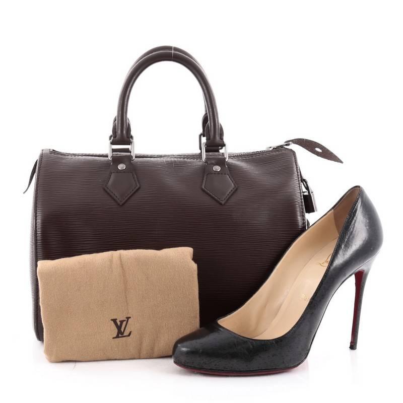 This authentic Louis Vuitton Speedy Handbag Epi Leather 25 is a timeless favorite of many. Crafted in dark brown epi leather, this bag features dual-rolled handles, subtle stamped LV logo, exterior side slip pocket and silver-tone hardware accents.