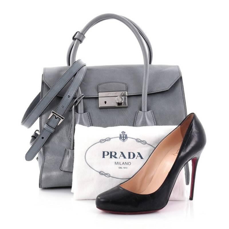 This authentic Prada Twin Pocket Lock Flap Tote Glace Calf Medium is a chic bag perfect for your everyday excursions. Crafted from marine blue gray leather, this stylish bag features dual-rolled leather handles, protective base studs and silver-tone