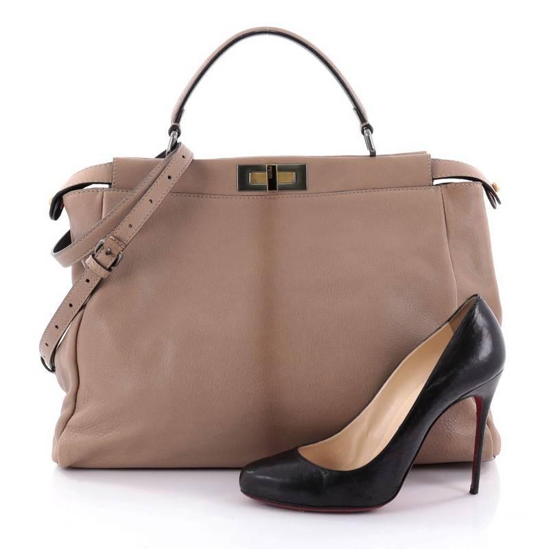 This authentic Fendi Peekaboo Handbag Leather with Python Interior Large is one of Fendi's best-known designs exuding a luxurious yet minimalist appearance. Crafted in light brown leather, this versatile and stylish satchel features a flat leather