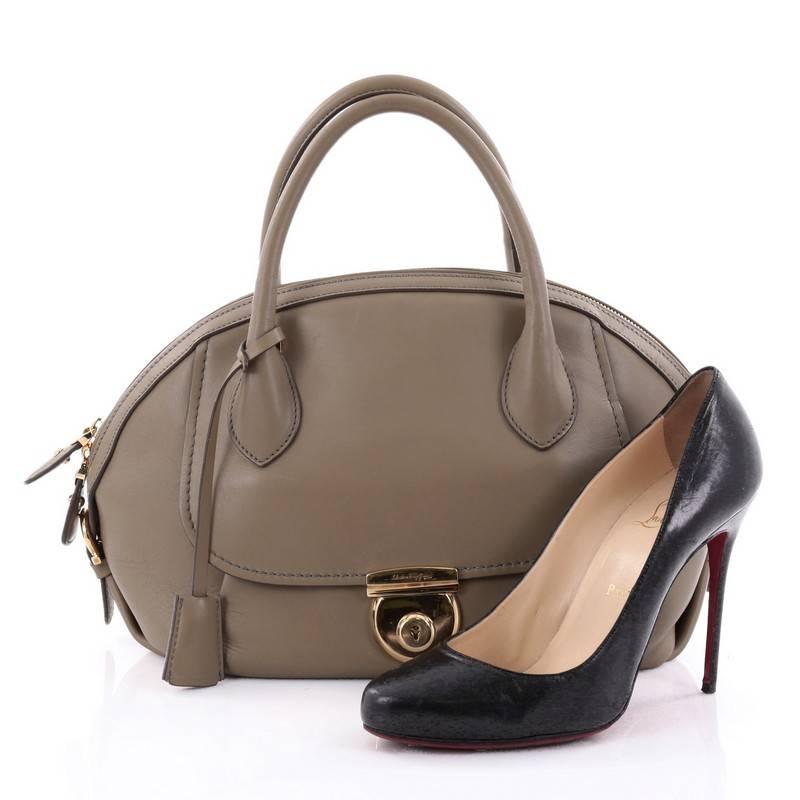 This authentic Salvatore Ferragamo Fiamma Satchel Leather Large is an ode to the classic 1990's Ferragamo design that's sophisticated and elegant in design perfect for everyday use. Crafted in taupe leather, this heritage-inspired dome satchel