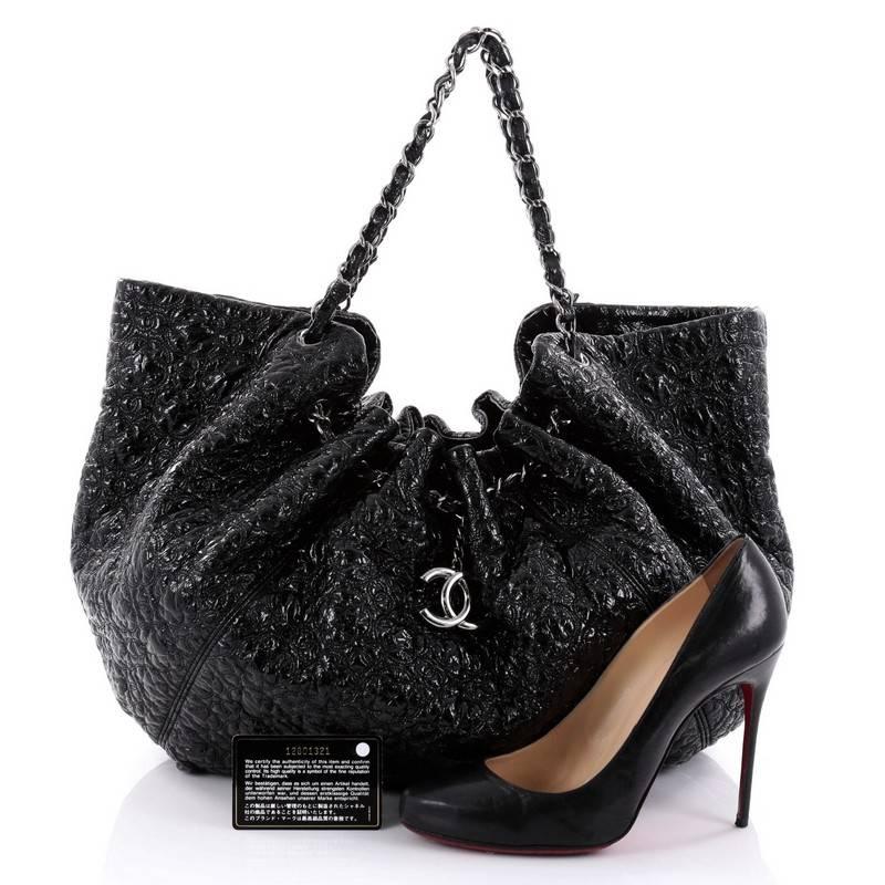 This authentic Chanel Rock In Moscow Cabas Patent Vinyl Large is perfect for everyday use with its modern and luxurious style. Crafted from black patent vinyl, this easy-to-carry tote features a ruched silhouette, geometric quilting details, dual