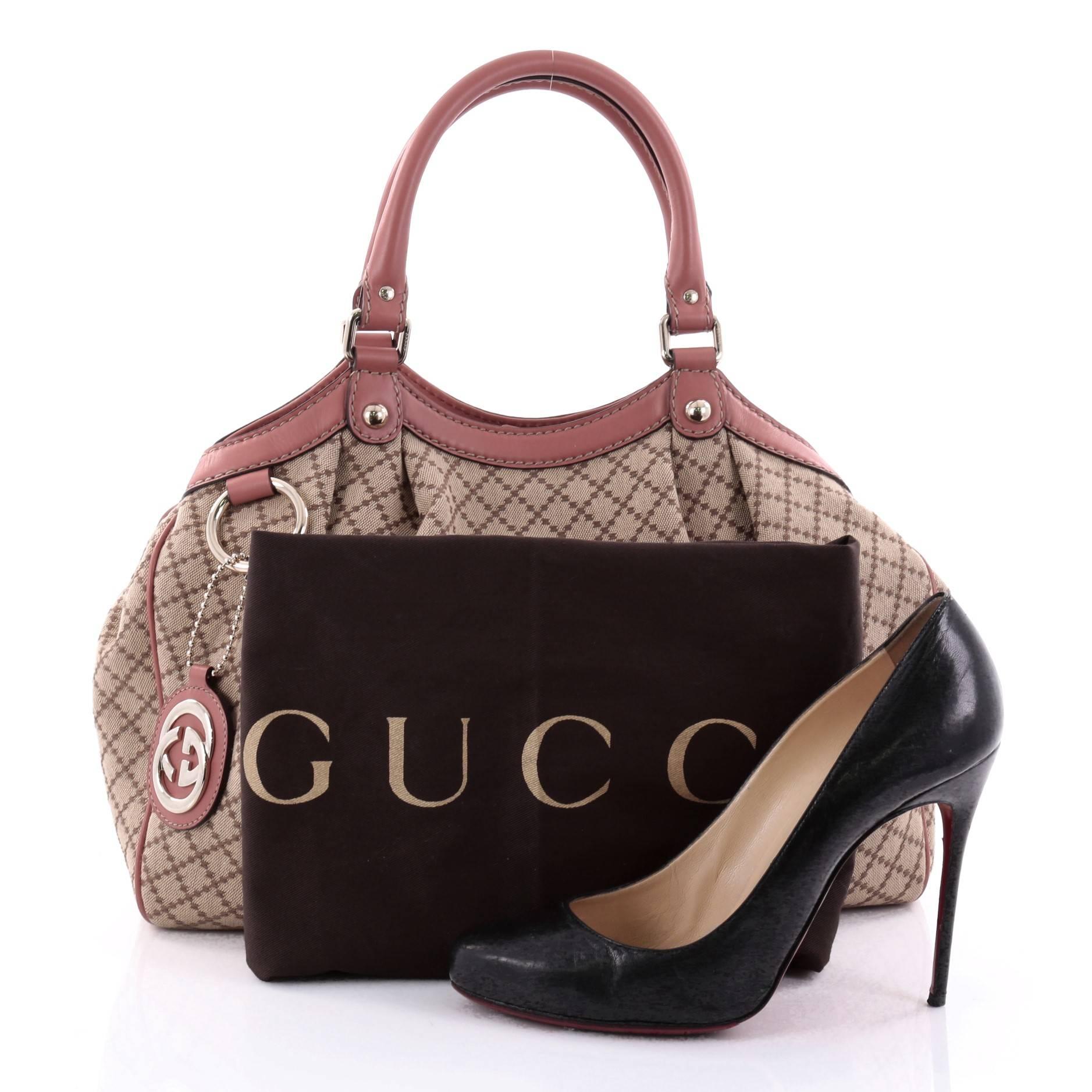 This authentic Gucci Sukey Tote Diamante Canvas Medium  is sophisticated and chic perfect for casual excursions. Crafted in light brown diamante canvas and pink leather trims, this soft bag features dual-rolled handles, pleated details, Gucci logo