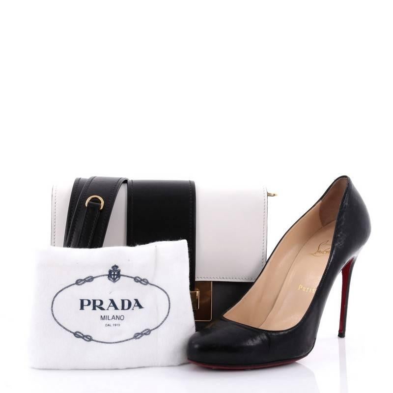 This authentic Prada Metal Ribbon Shoulder Bag City Calfskin Small is a stylish and unique bag perfect to add to your collection. Crafted in grey, black and white leather, this convertible bag features removable shoulder strap, flap top with