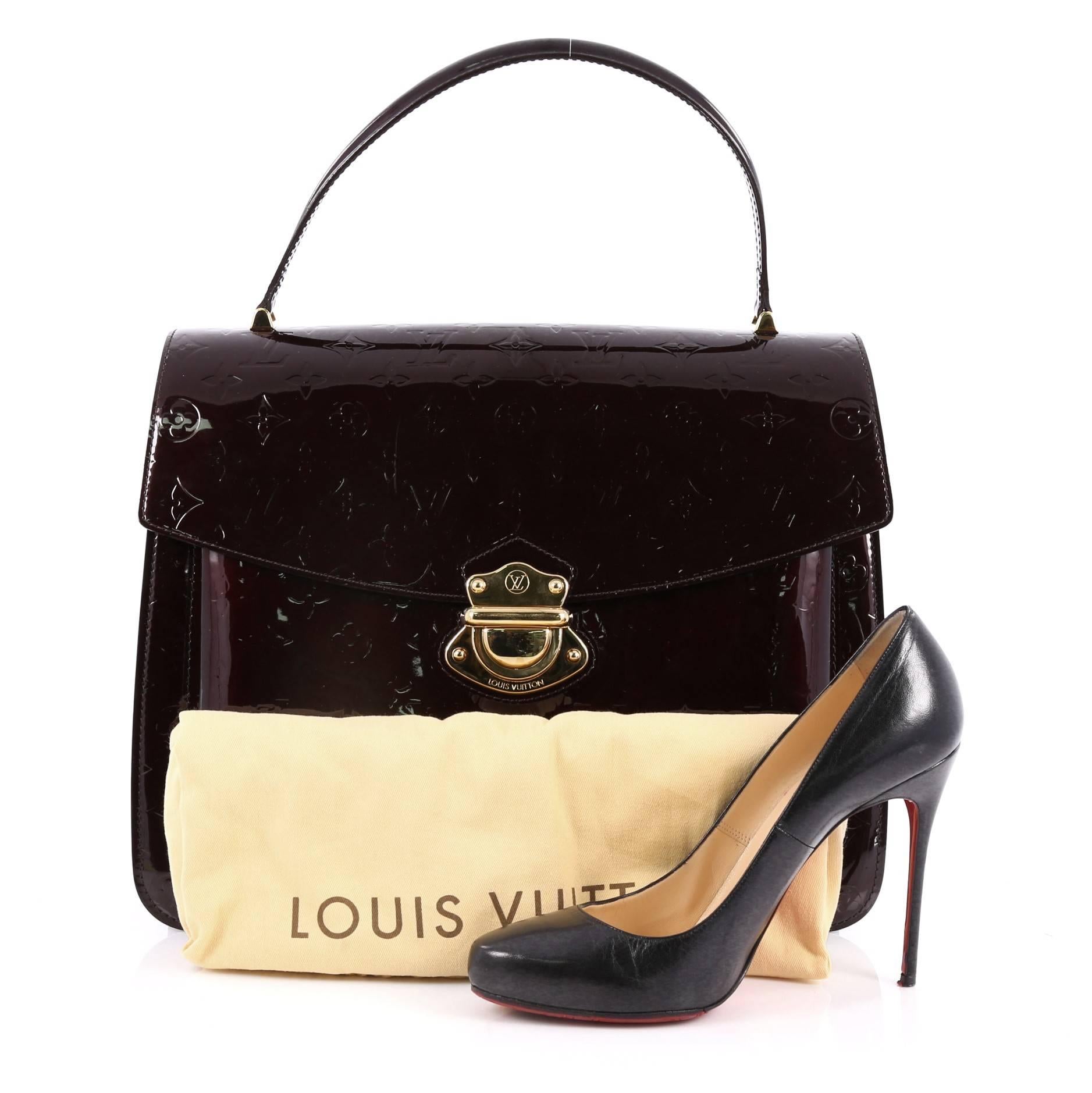 This authentic Louis Vuitton Romaine Handbag Monogram Vernis is a retro chic bag showcasing a timeless design made for the modern woman. Crafted from amarante red monogram vernis, this luxurious tote features a short top handle, exterior zip back
