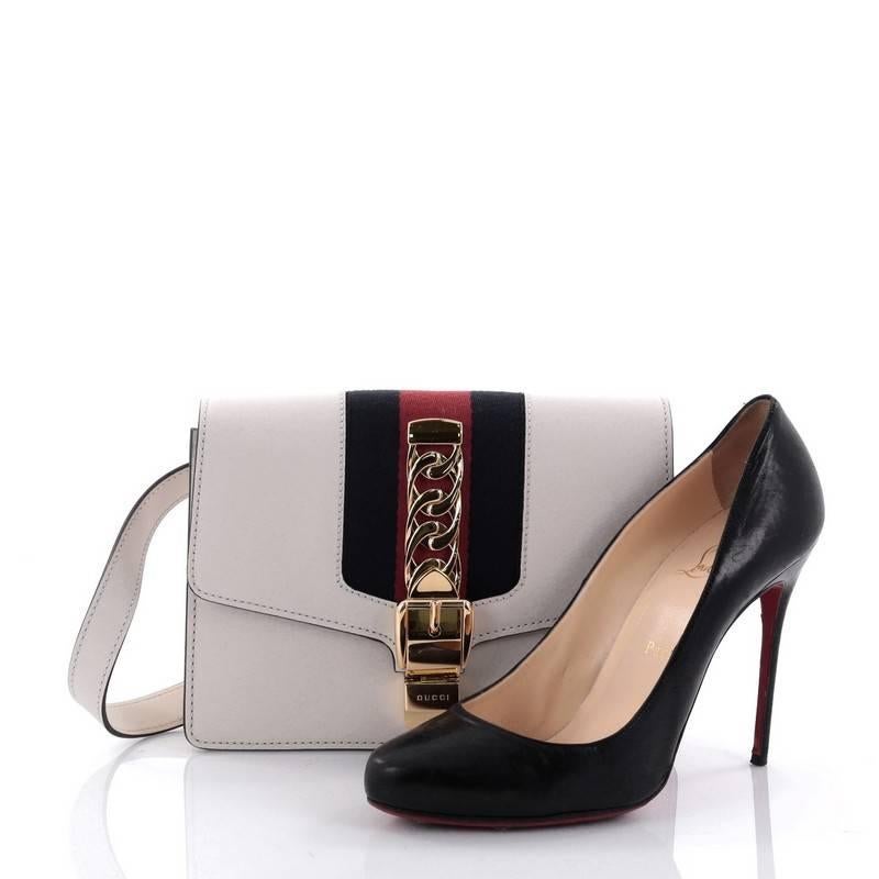 This authentic Gucci Sylvie Belt Bag Leather is a structured shape bag perfect for the modern fashionista. Crafted from white leather, this structured bag features adjustable belt strap, nylon Web detail with curb chain and buckle closure and