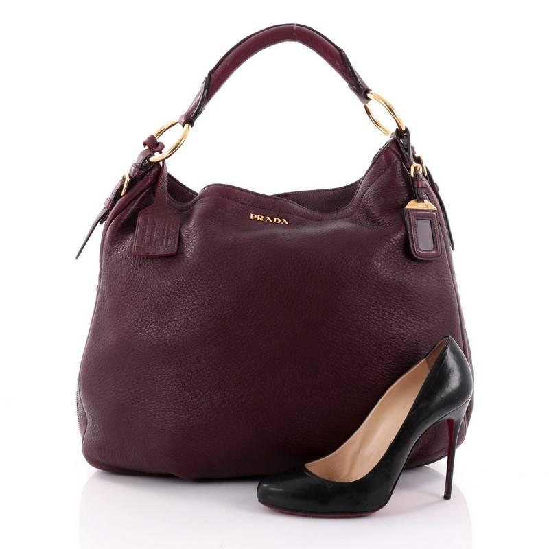 This authentic Prada Zip Around Hobo Cervo Antik Leather Large is simple and classic in design, perfect for everyday use. Crafted in burgundy cervo antik leather, this hobo features single rolled leather handle, zip around details for expansion,
