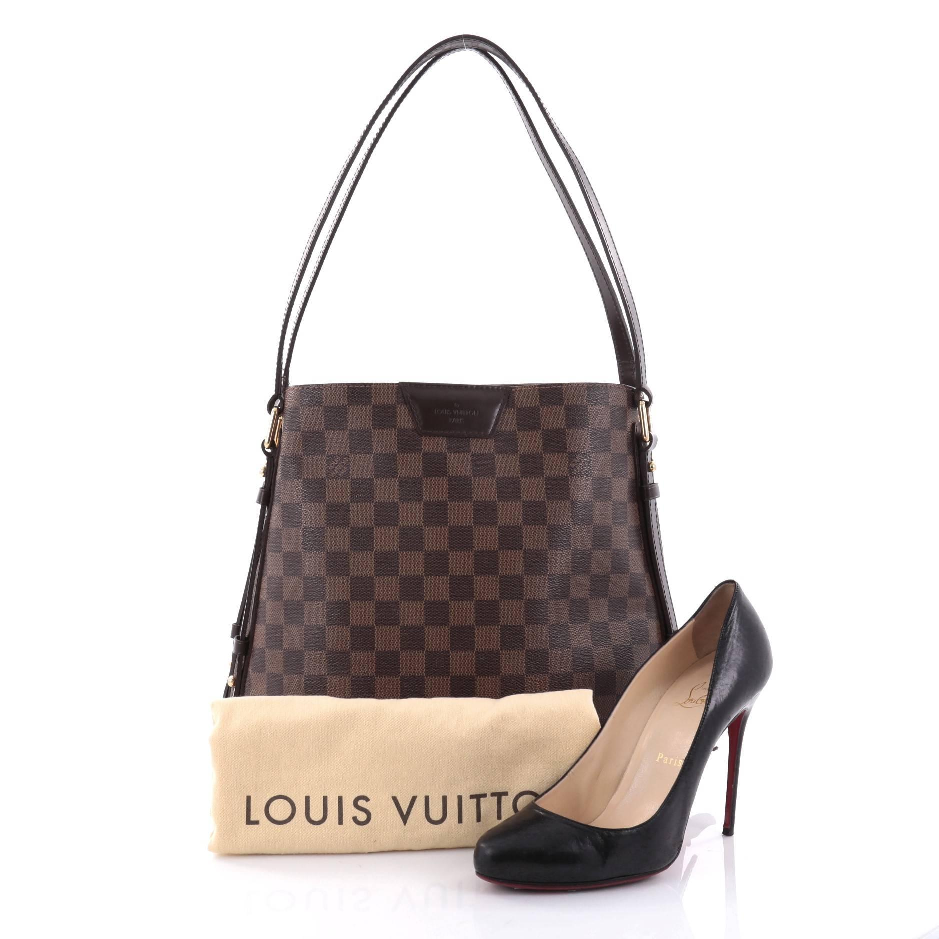 This authentic Louis Vuitton Cabas Rivington Damier has fashion and functionality both rolled into one. Crafted from damier ebene coated canvas with smooth chocolate leather trims, this chic bag features dual flat-leather handles, two side zippers