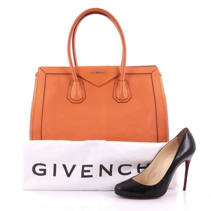 This authentic Givenchy Antigona Side Zip Tote Leather Medium combines style and functionality all-in-one. Crafted in orange leather, this stylish bag features dual rolled top handles, dual zip expansion gussets at sides, logo placard at front and
