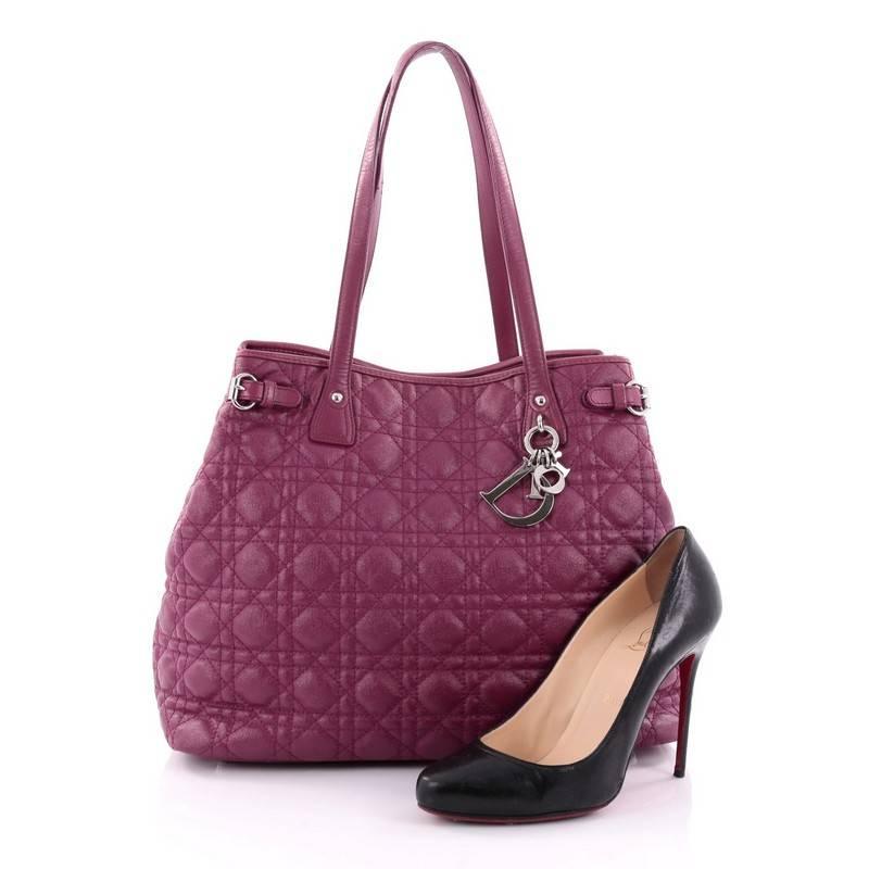 This authentic Christian Dior Panarea Tote Cannage Quilt Canvas Medium is a classic for every fashionista. Crafted in purple cannage quilted canvas, this chic tote features slim dual-flat handles, silver Dior charms, side belt accents, protective