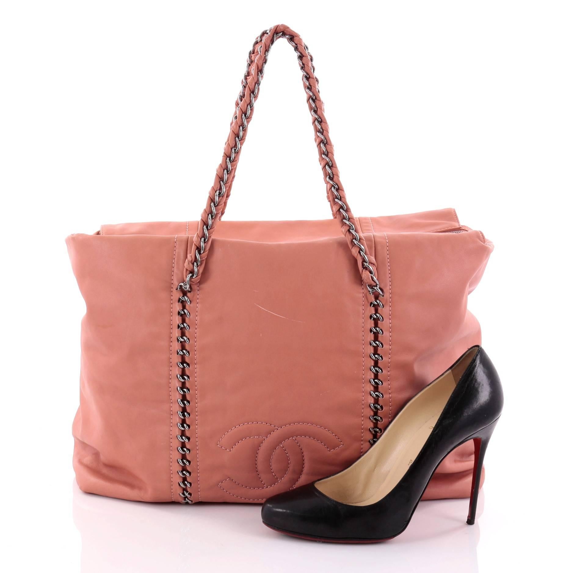 This authentic Chanel Luxe Ligne ZIp Top Tote Calfskin Large is perfect for an on-the-go fashionista. Constructed from dusty rose calfskin leather, this tote features braided woven leather chain straps, stitched chain details with Chanel CC logo