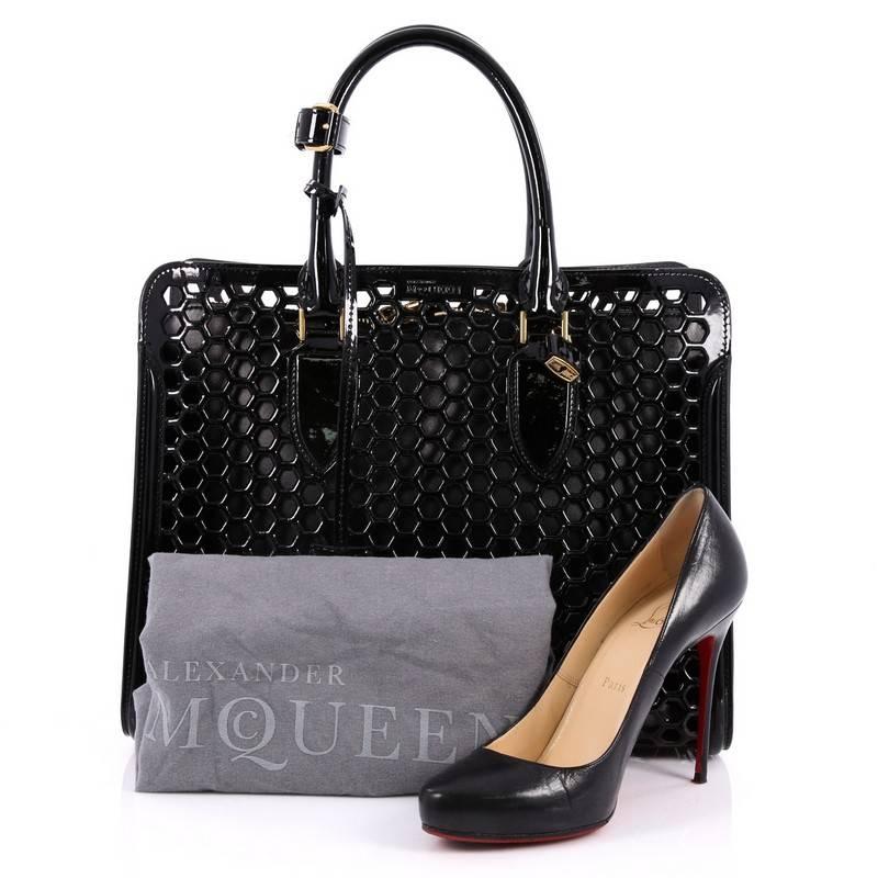 This authentic Alexander McQueen Heroine Open Tote Honeycomb Patent Leather Large combines functional style with luxurious design. Constructed in sleek black honeycomb patent leather, this oversized tote features a structured silhouette, dual-rolled