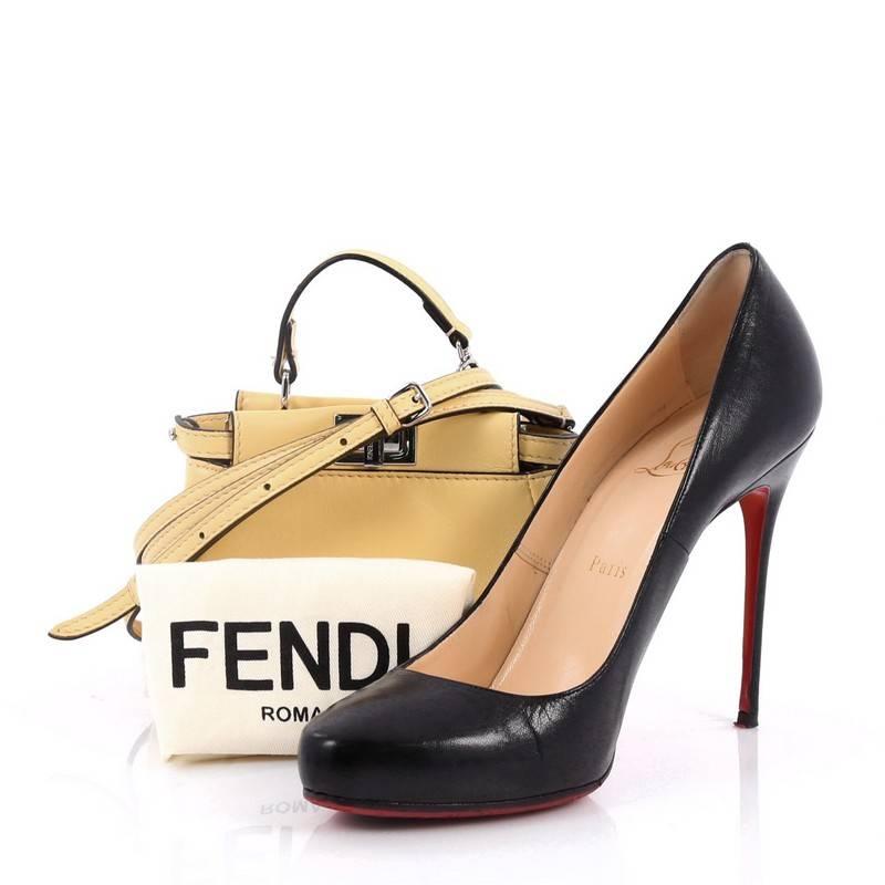 This authentic Fendi Peekaboo Handbag Leather Micro is one of Fendi's most sought-after design. Crafted from yellow leather, this micro-size satchel is accented with a top frame silhouette, flat leather handle, dual compartments with turn-lock and