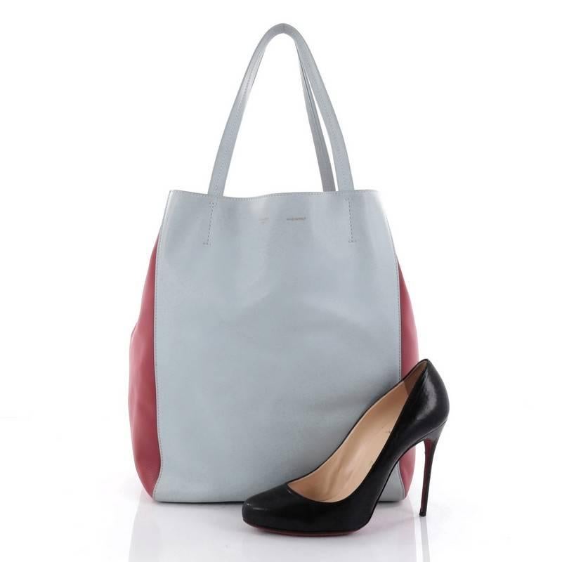 This authentic Celine Bicolor Phantom Cabas Tote Leather Medium is the perfect everyday shopper tote. Crafted in light blue and red leather, this tote features dual slim leather handles, stamped gold Celine logo, and extended side ties. Its spacious