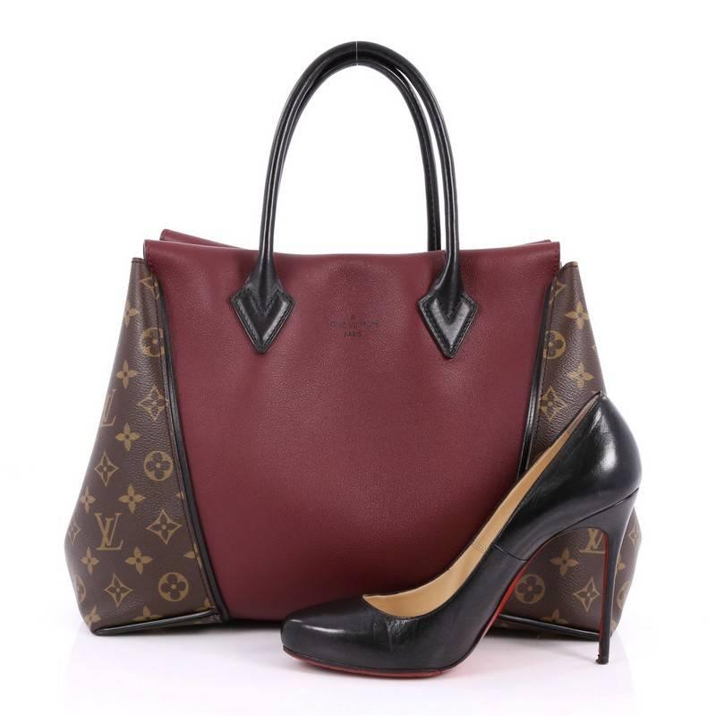 This authentic Louis Vuitton W Tote Monogram Canvas and Leather PM presented in the brand's 2013 Collection is a collector’s dream. Crafted in maroon leather with brown monogram coated canvas sides, this luxurious and elegant tote features