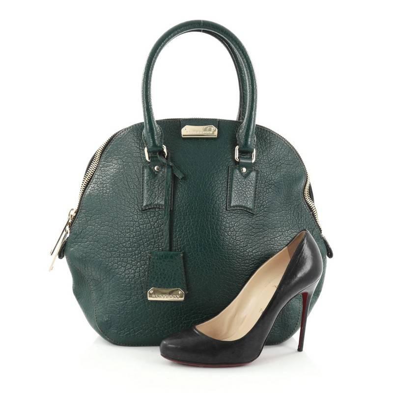 This authentic Burberry Orchard Bag Heritage Grained Leather Medium has a glamorous design with a roomy silhouette that is ideal for everyday use. Crafted from dark green grained leather, this vintage-inspired bag features dual-rolled leather