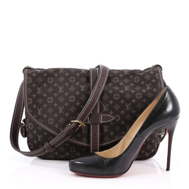 This authentic Louis Vuitton Saumur Handbag Mini Lin showcases the brand's reinterpretation of the classic saddle bag with style and functionality. Crafted in Louis Vuitton's popular dark brown mini lin monogram canvas, this stylish crossbody bag
